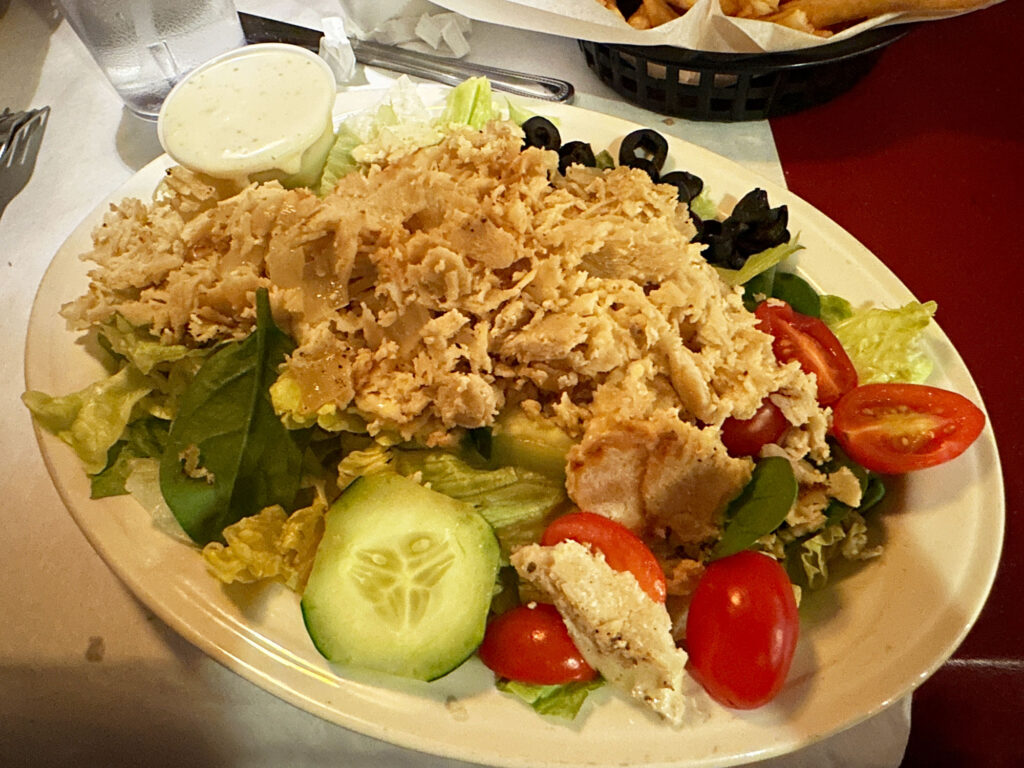 salad topped with chicken cheesesteak
