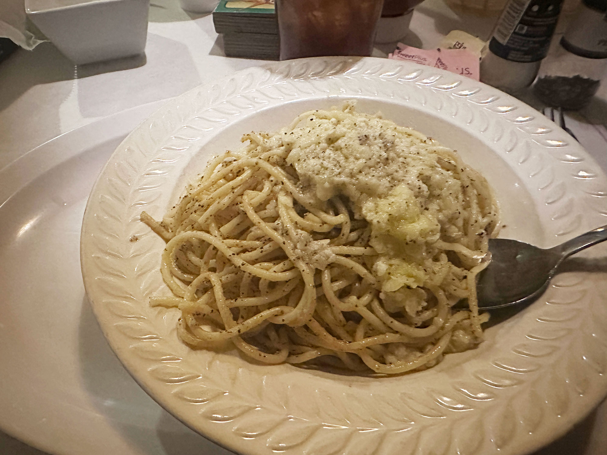 bowl of spaghetti tossed with cheese and pepper flakes