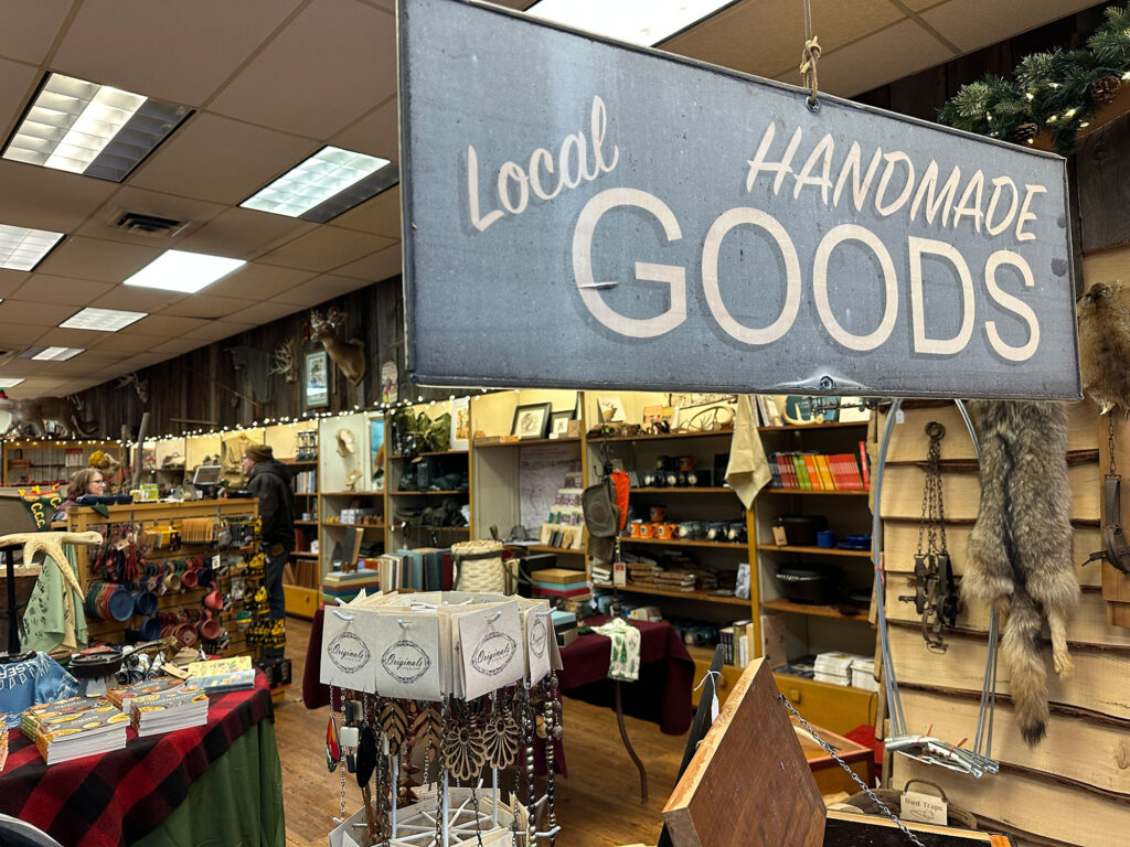 large banner sign reading "Local Handmade Goods" in a large retail space with shelves of various product in the background