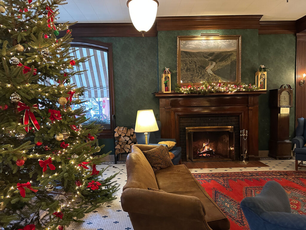 hotel lobby with fireplace, leather couch, and a Christmas tree on the left 