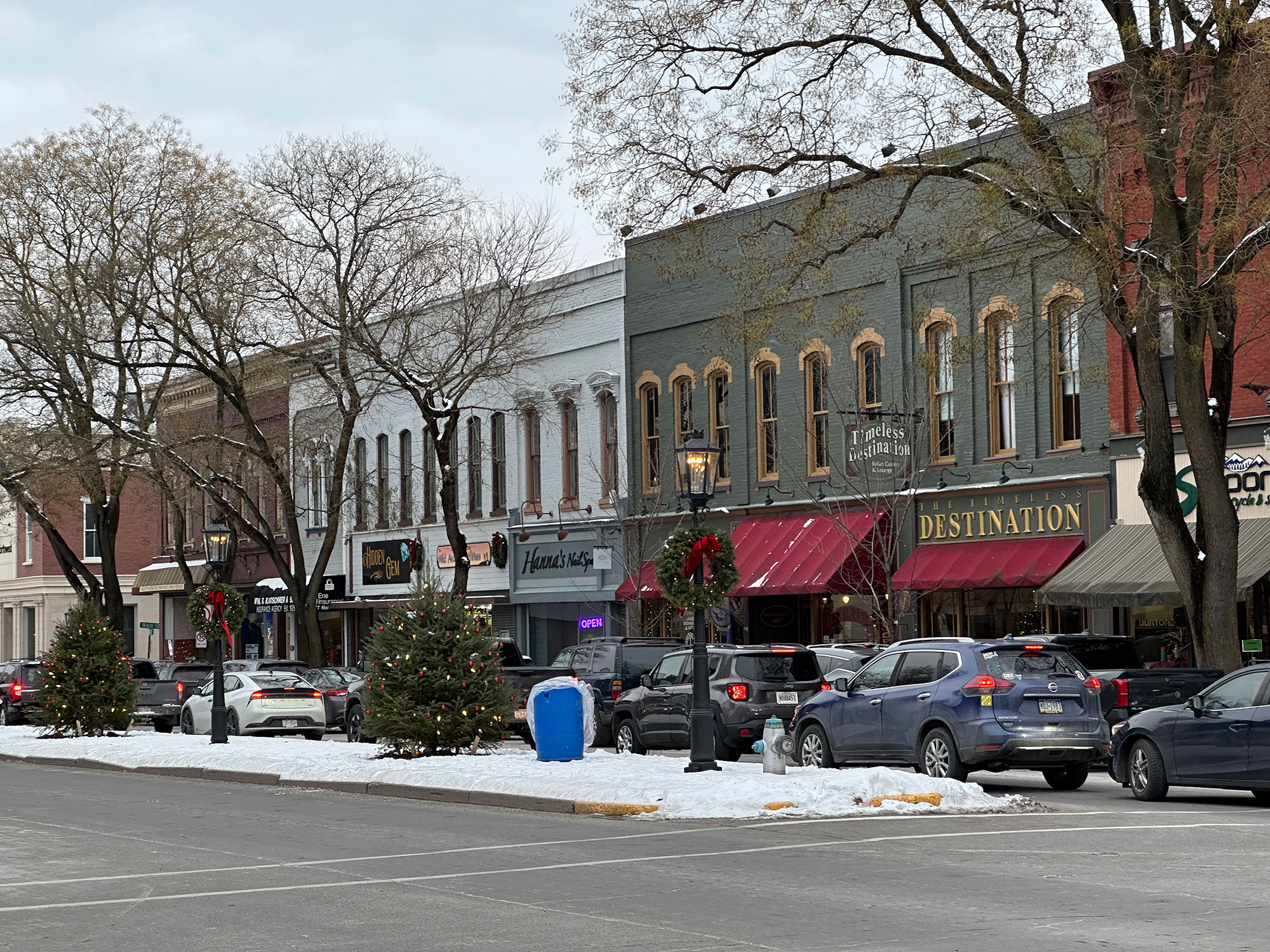 snowy street lined with cars and businesses in Wellsboro, PA