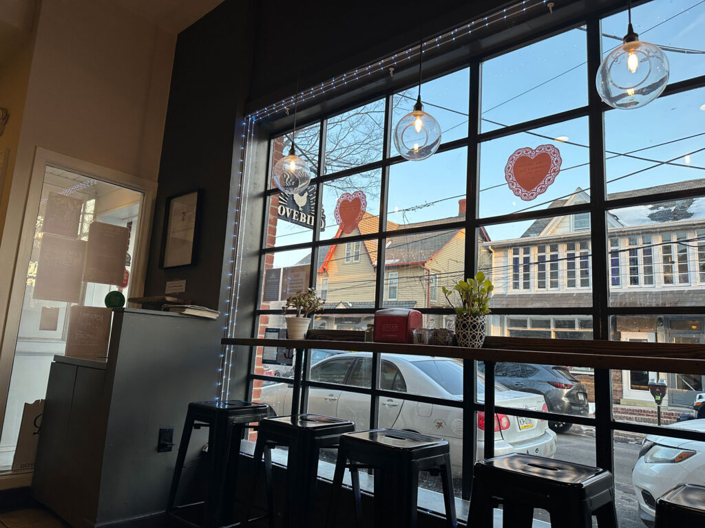 tall metal stools at a counter seating by a large picture window at Lovebird in Doylestown