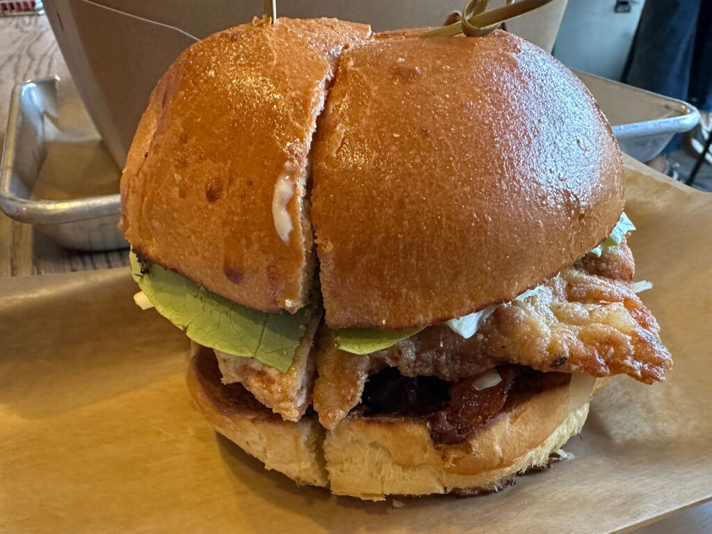 chicken sandwich on a bun with onion jam, bacon, lettuce and cheese from Lovebird in Doylestown, PA