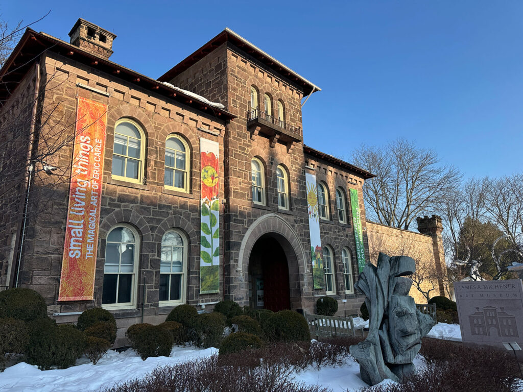 Large stone structure with vetical banners hanging down showing artwork by Eric Carle